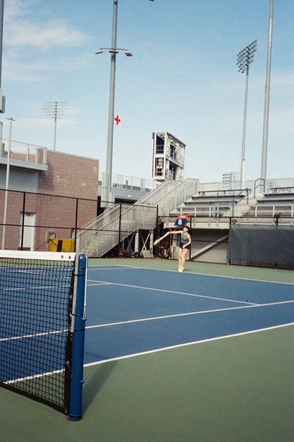 Lily on an outdoor tennis court