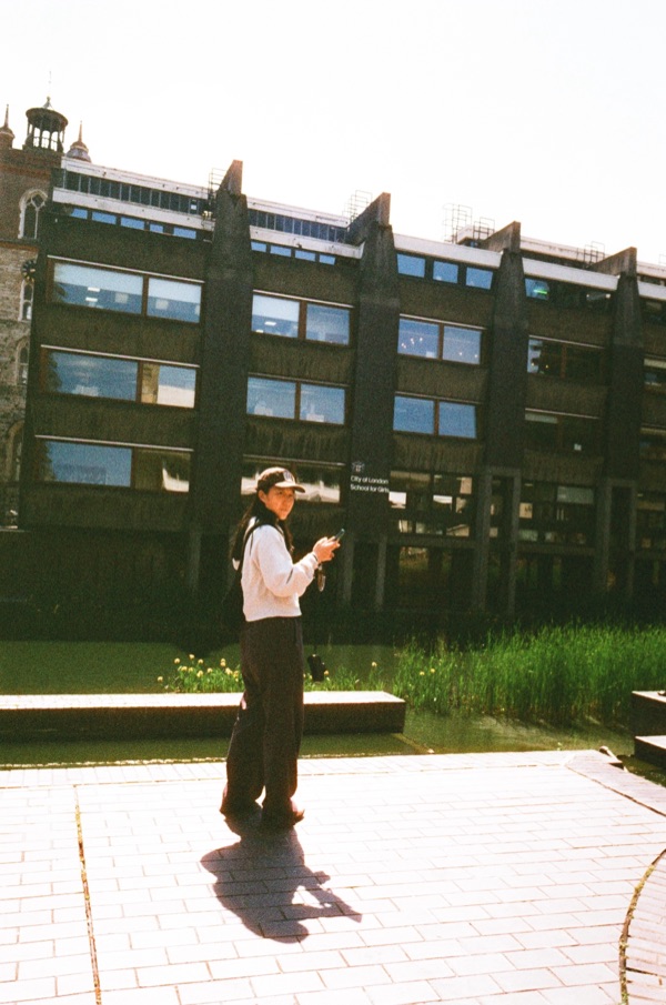 Lily outside a brick building on a sunny day
